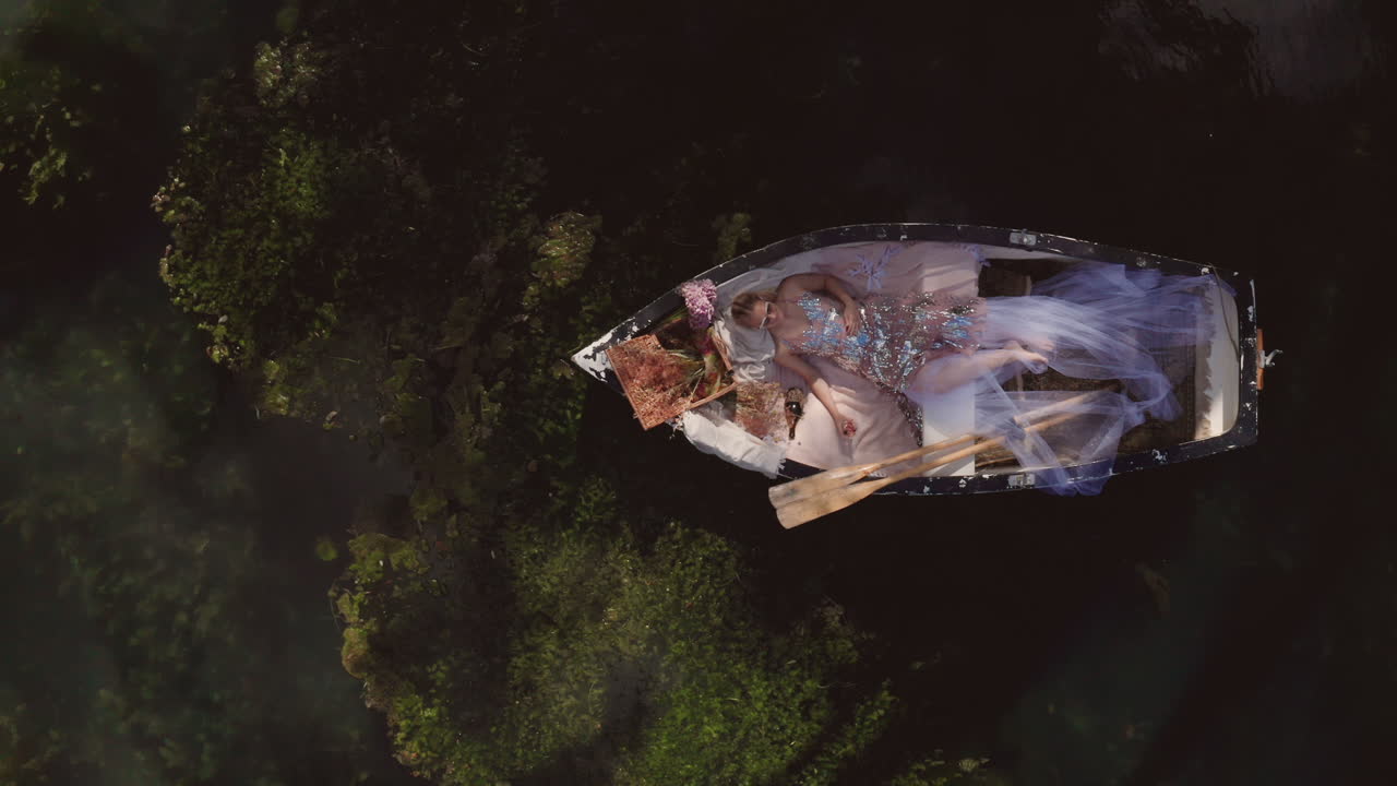 Dreaming concept, social media influencer creating a new photo for her blog, fashionista laying in rowing boat, top down aerial