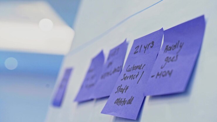 Colorful sticky notes on wall during brainstorming workshop, close-up