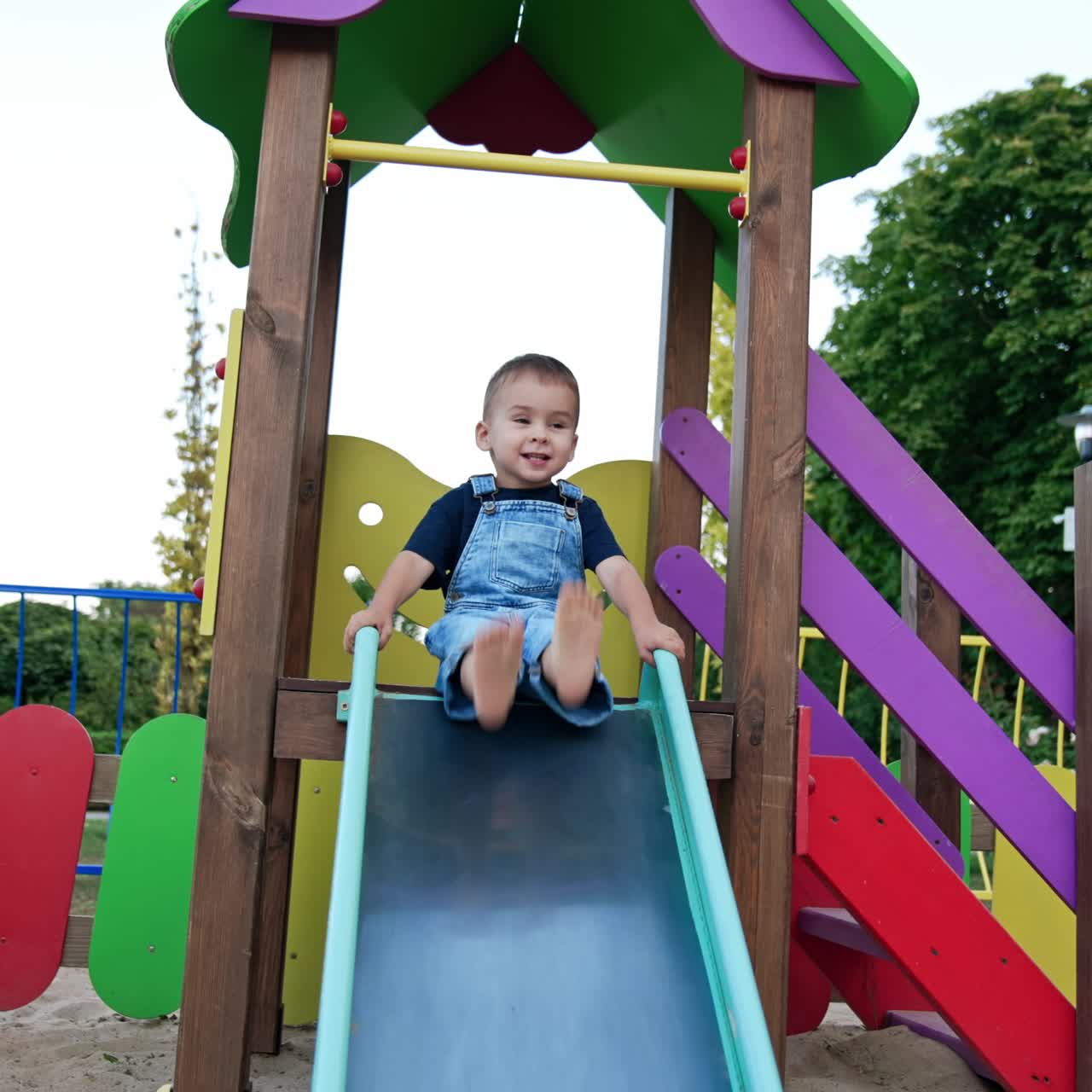 Small boy on colorful playground. Happy little playful child in park