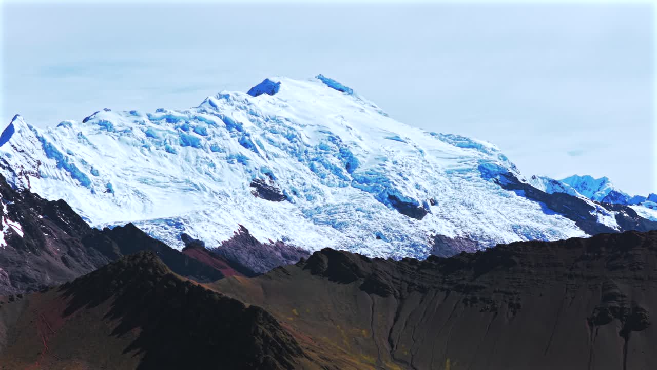 Peruvian Andes Ausangate Glacier Rainbow Mountain Vinicunca Peru Perú glacial Nevado Auzangate Vilcanota Cusco Region morning blue sky clouds Hatun Ritty rainy season pan left motion