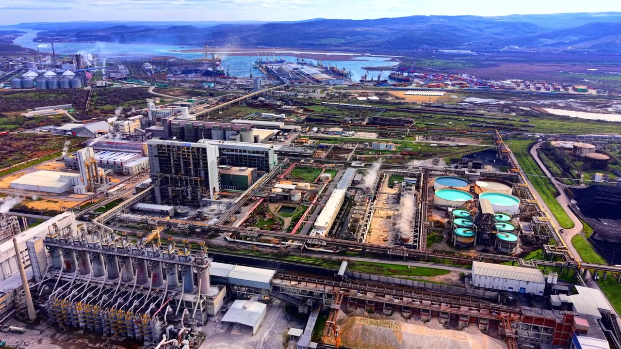Aerial view of a large chemical industrial complex, Varna, Bulgaria. Factories, smokestacks, storage tanks, shipping port and coastal landscape under day light.