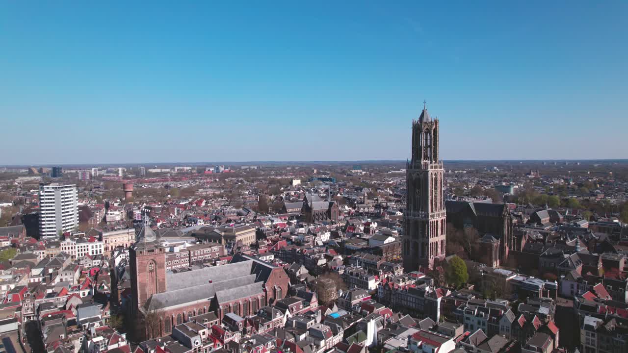 Cityscape aerial of city center Utrecht, The Netherlands, on a bright sunny day with church and cathedral rising above the low build picturesque canal homes. Urban development and Dutch flat landscape