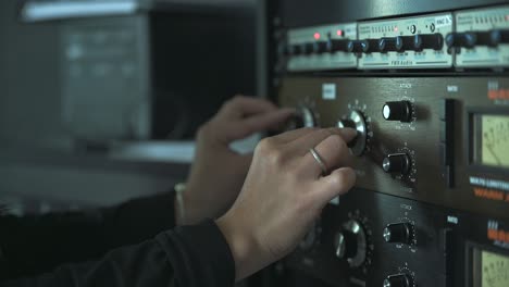 mujer presentadora de radio ajustando la configuración en la consola mezcladora