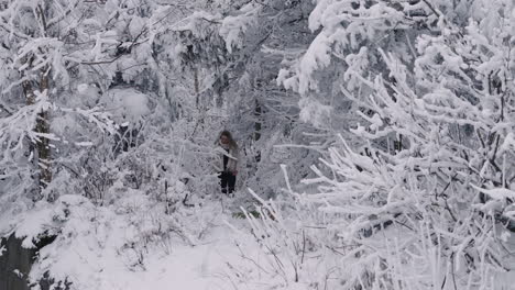Frau-Zu-Fuß-In-Der-Wildnis-Mit-Schneebedeckten-Ästen-Und-Laub-In-Orford,-Quebec,-Kanada