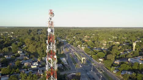 torre de comunicación con antenas y tráfico por carretera en la zona suburbana de la ciudad, vista aérea