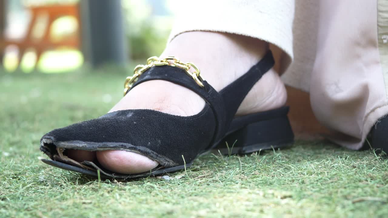 los zapatos desgastados de una mujer están en la hierba.