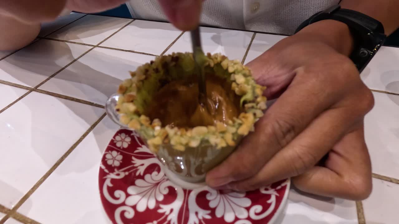 persona agitando café de pistacho en una taza