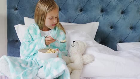 girl playing with teddy bear while having breakfast 4k