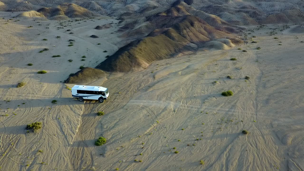 ripresa aerea di un autobus fuoristrada che guida nel deserto