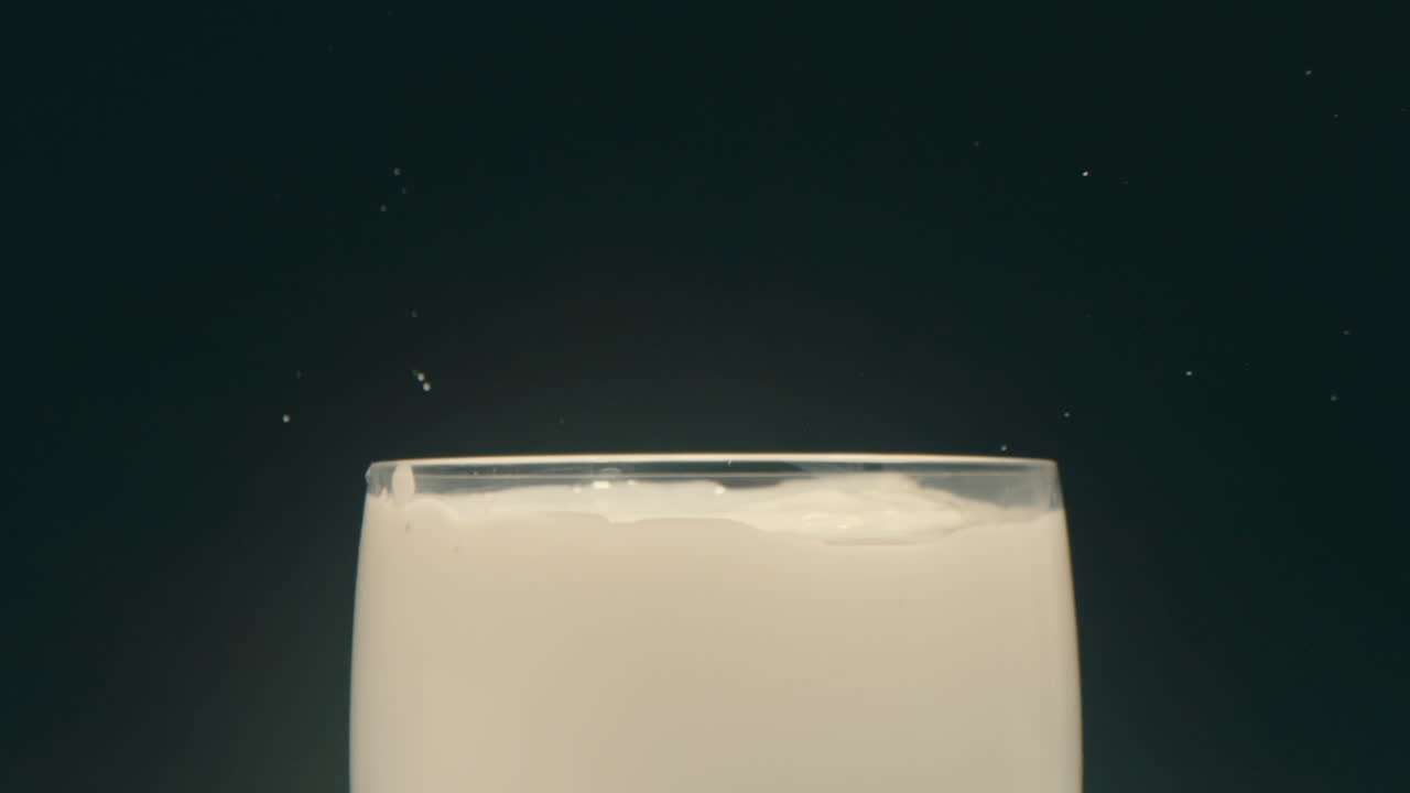 오레오 쿠키가 우유 한 잔에 떨어지고 느린 동작으로 어집니다.