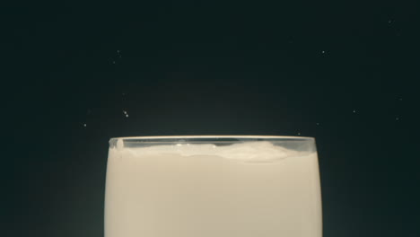 galleta oreo cayendo en un vaso de leche y salpicando en cámara lenta