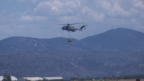 helicóptero militar que lleva carga sobre la montaña