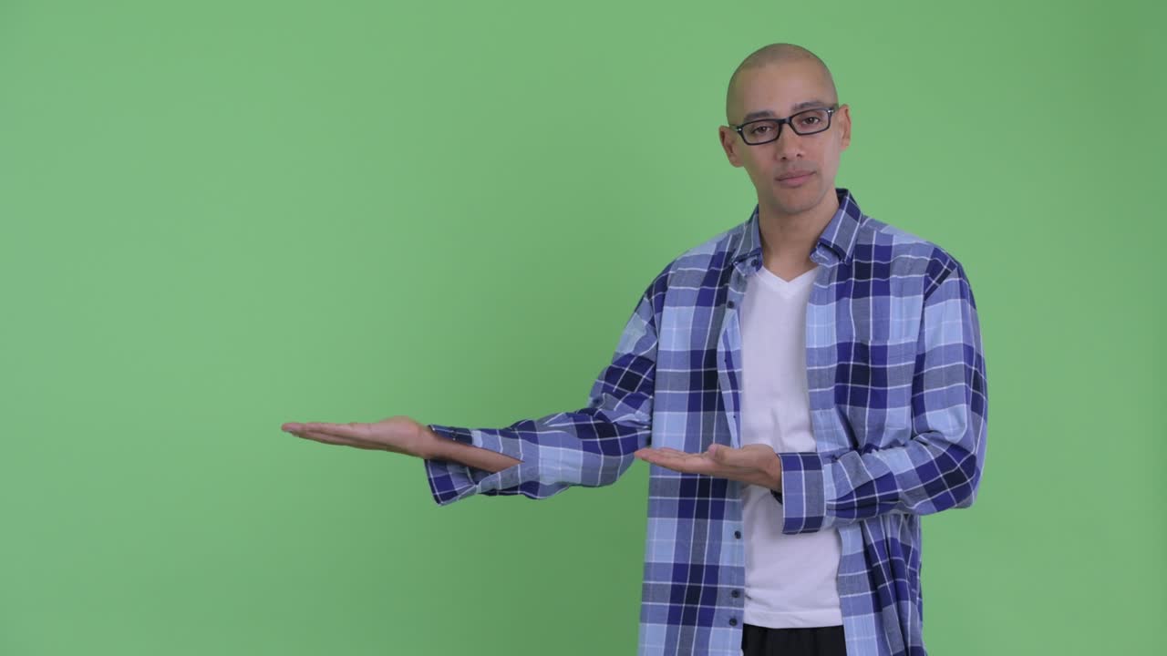 Stressed bald hipster man showing something