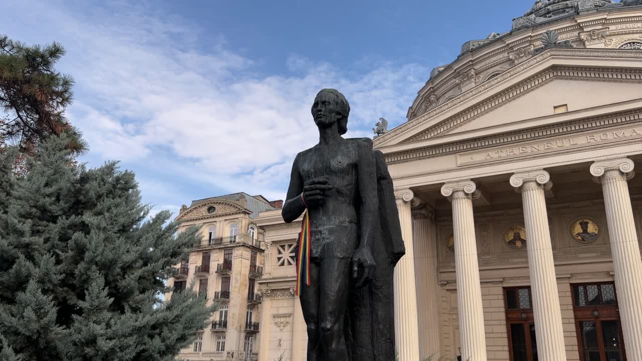 solemn bronze statue standing by ornate columns in a public Romanian square