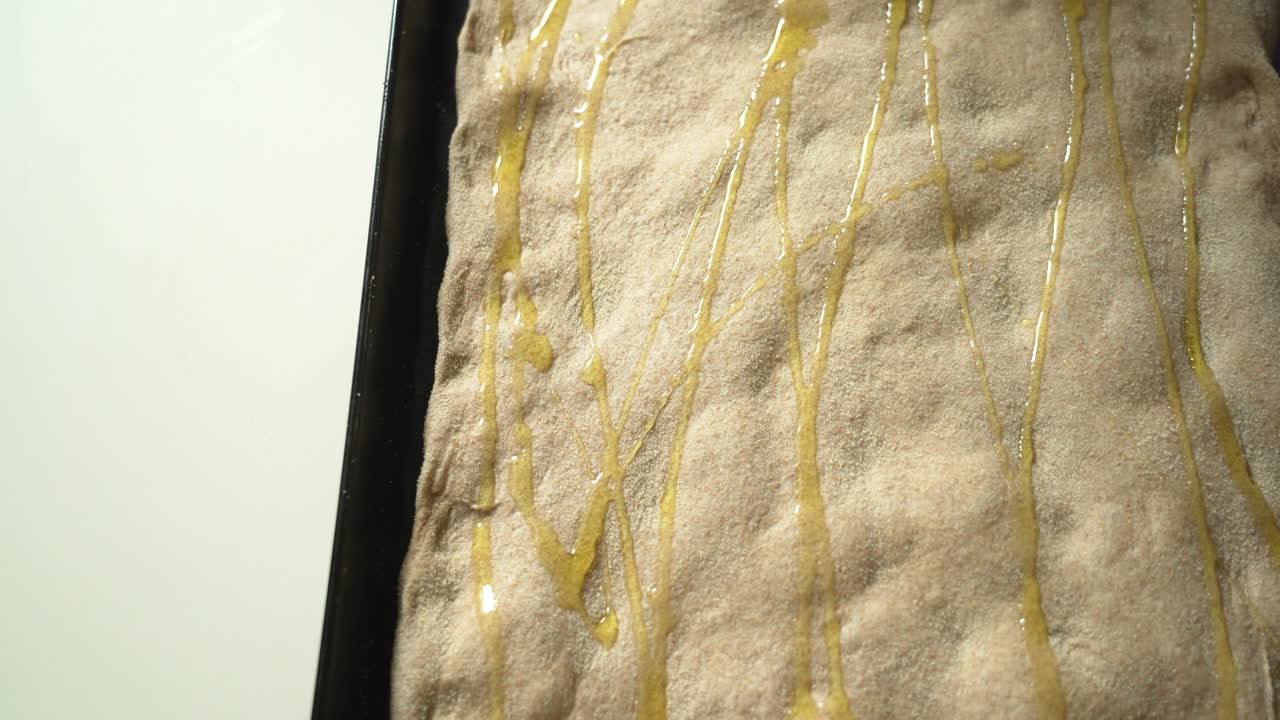 시트 팬 피자에 올리브 오일을 바르고