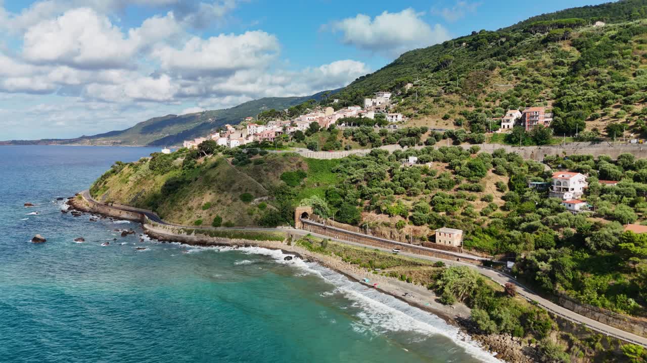 Scenic coastal road by lush green hillside, sunlight and blue sea view