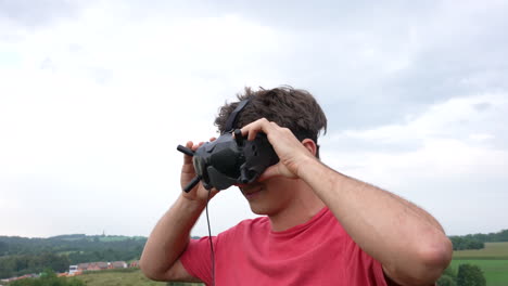 Young-Man-Placing-Goggles-Headset-With-Antennas-on-His-Head,-Virtual-Reality-and-FPV-Concept