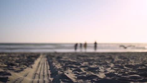 Beautiful,-calm-and-peaceful-sunset-in-San-diego,-shooting-down-a-tire-tread-mark-left-in-the-sand