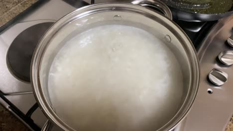 primer plano de la cocción del arroz, liberando vapor aromático, creando una escena tentadora de preparación culinaria