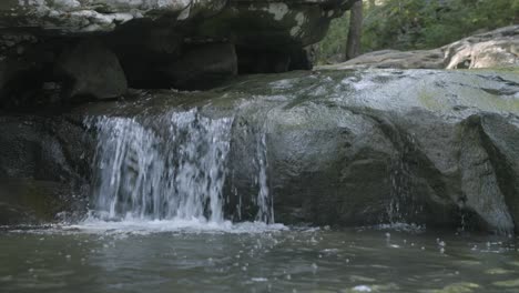 Imágenes-De-Cerca-De-Una-Pequeña-Cascada-Saliendo-De-Una-Roca-En-Un-Arroyo