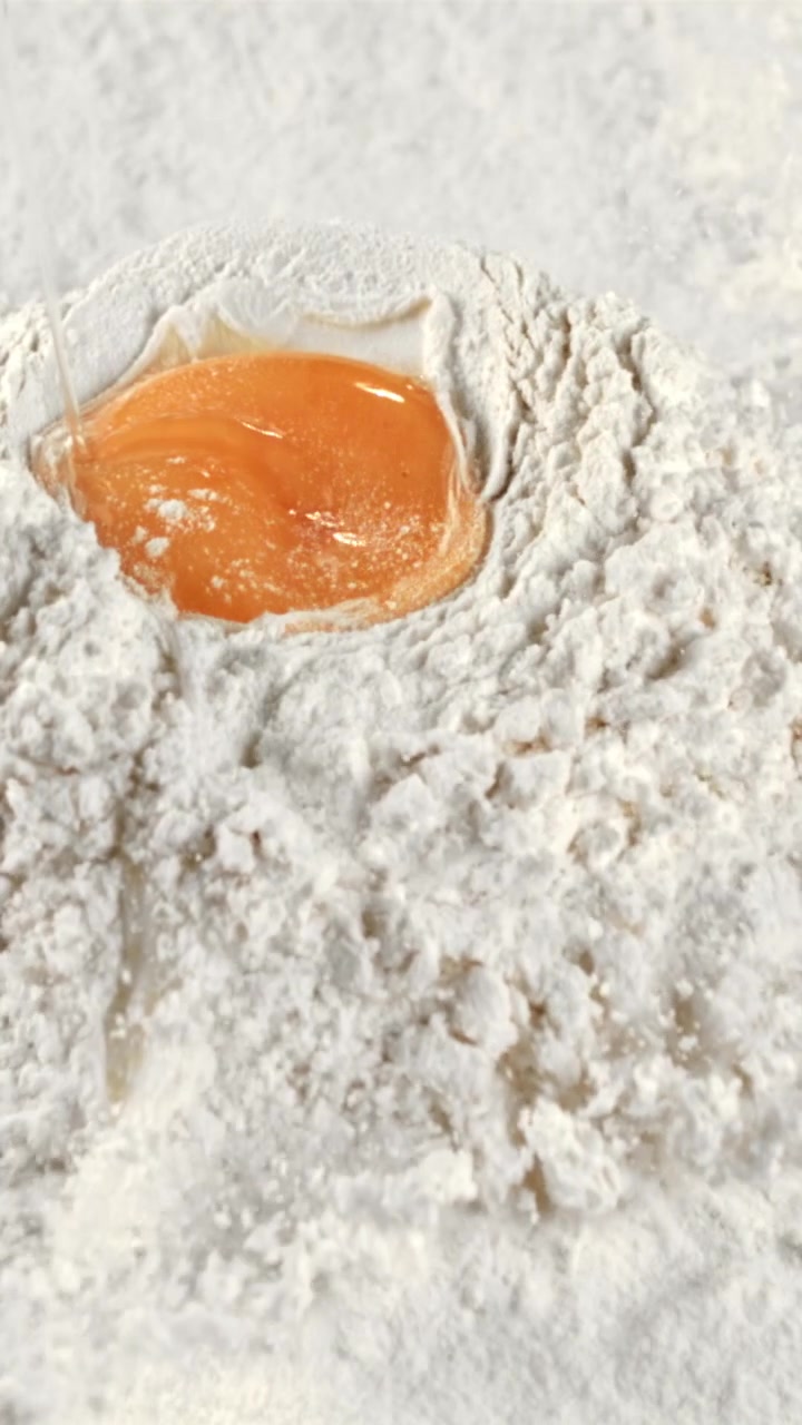 Slow Motion of Egg Yolk and White Dropping into Flour