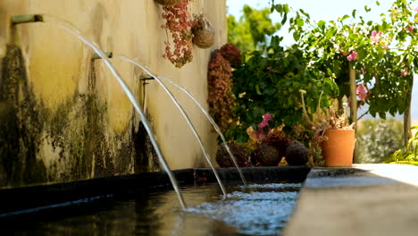 Three-water-streams-cascading-into-pond,-relaxing-meditation-scene