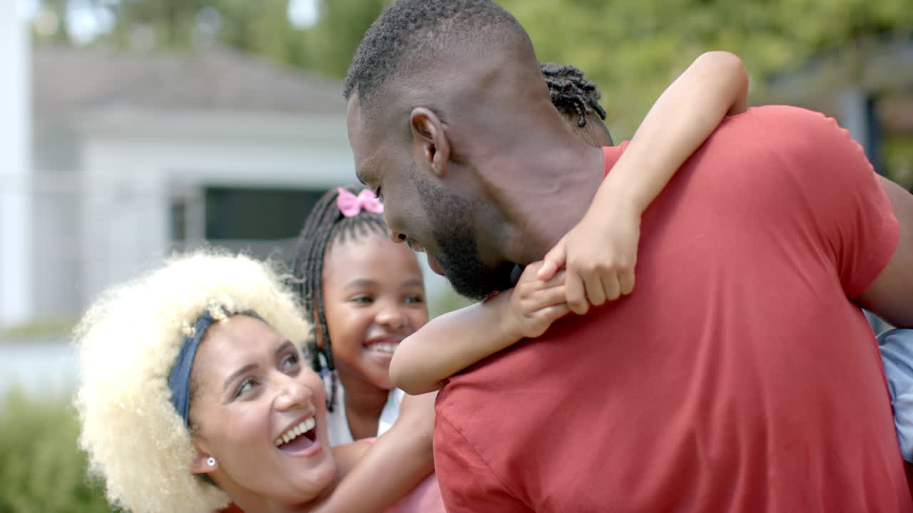 Famiglia afroamericana che si gode il tempo a bordo piscina a casa.