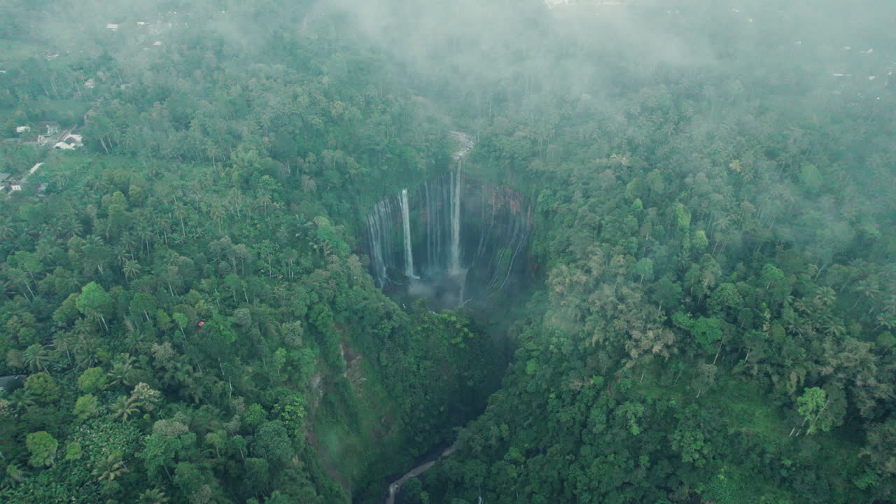 Indonesia waterfall Tempak Sewu in East Java covered under clouds ...