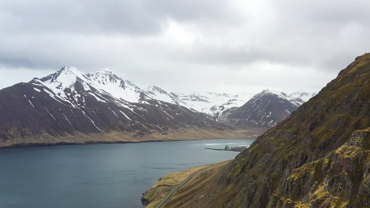 vista aérea de un majestuoso paisaje islandés, con montañas cubiertas de nieve y un sereno fiordo