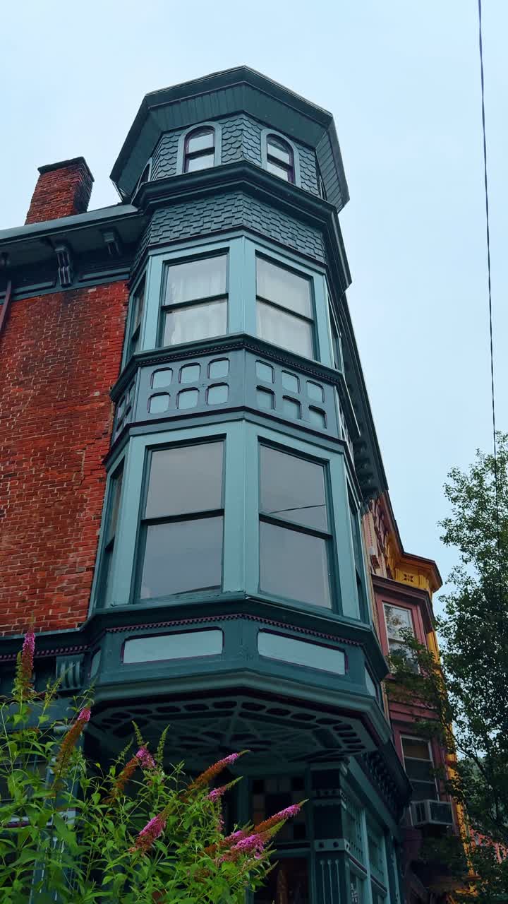 Jim Thorpe, USA, 2 luglio 2025: Architettura dell'era vittoriana con bovindo color verde acqua a Jim Thorpe. Angolazione dal basso di un edificio storico in mattoni con una torre a bovindo in legno dipinta di verde acqua.