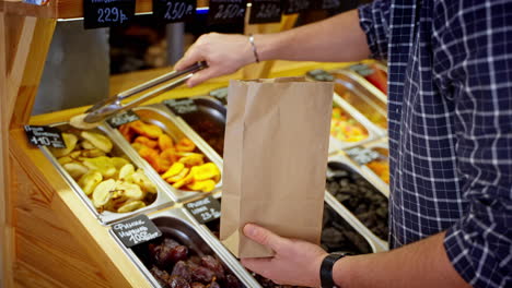 customer buying dried fruits at a market