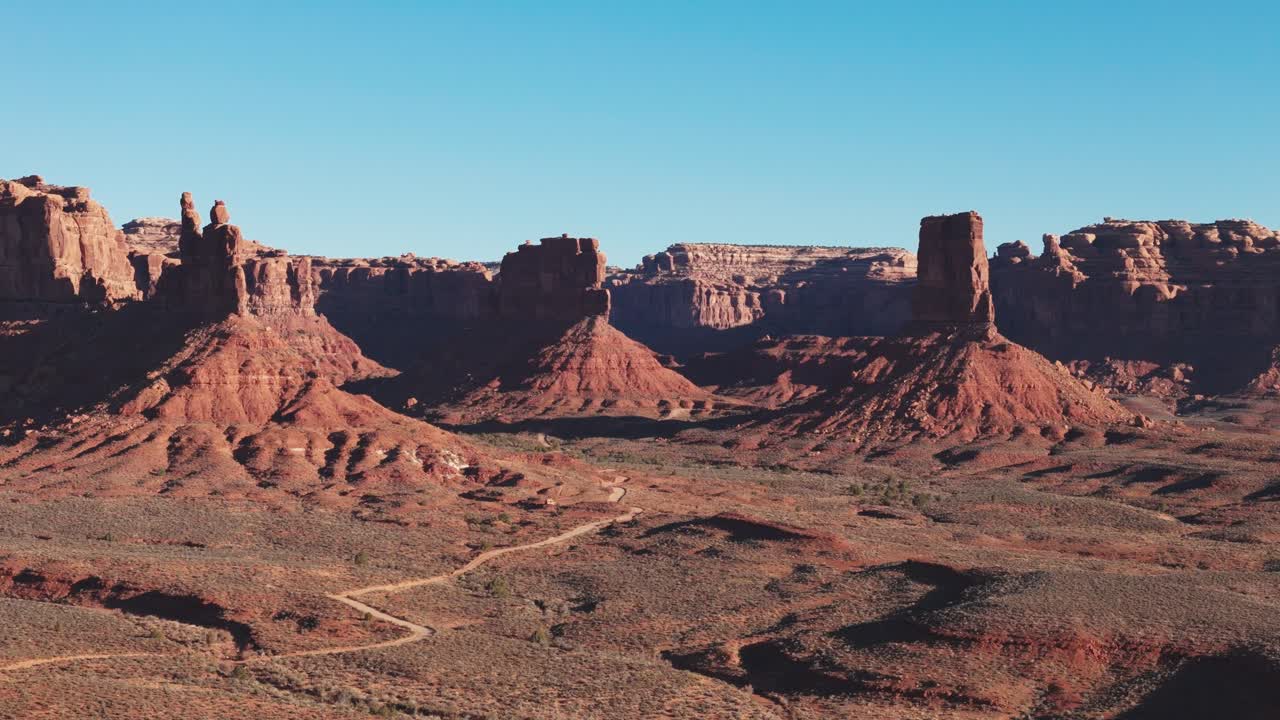 Ampia inquadratura di apertura con drone che si avvicina sulla Valle degli Dei nello Utah alla luce del mattino.