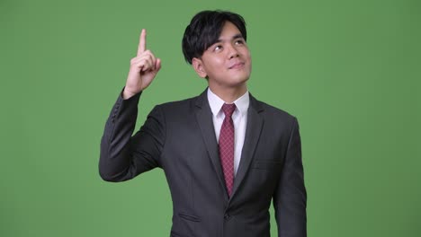 젊은 잘생긴 아시아 사업가 손가락을 가리키며