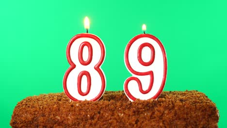 cake with the number 89 lighted candle. chroma key. green screen. isolated