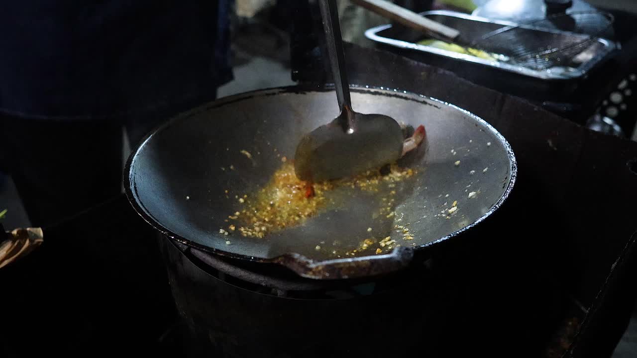 Cucinare gamberi e basilico saltati in padella in un wok