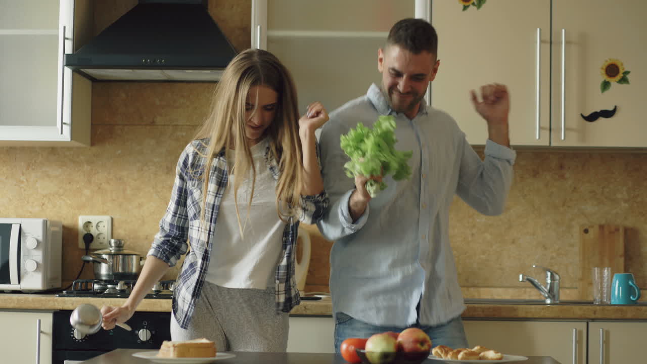 Happy Couple Singing and Dancing in the Kitchen