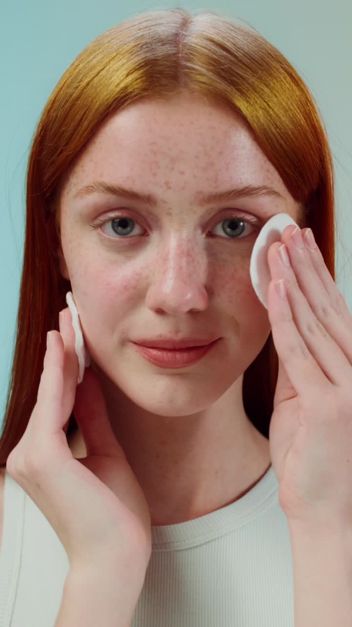 mujer limpiándose la cara con almohadillas de algodón