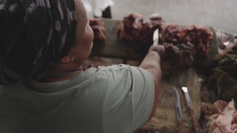 african woman cutting the meat