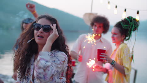 beautiful woman dancing with sparkler at lake party