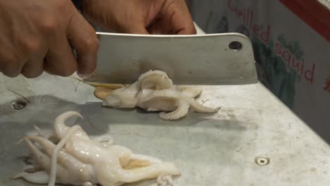 cortando el procesamiento de la sepia en el mostrador en un restaurante de comida callejera