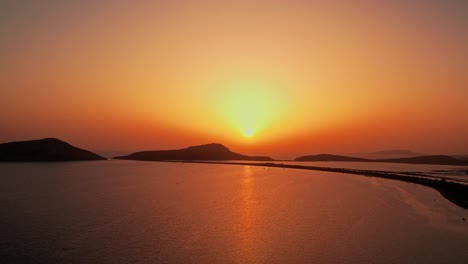 Pacífica-Puesta-De-Sol-Extendiendo-Rayos-Amarillos-Dorados-A-Un-Gradiente-Rojo-Anaranjado-Sobre-El-Océano-Pylos-Grecia