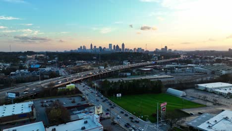 Aerial-establishing-shot-of-traffic-on-highway-in-front-of-Atlanta-city-Skyline