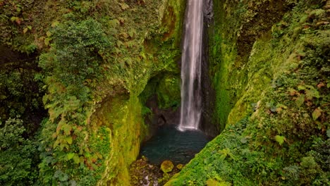 an breathtaking aerial view reveals the unique and beautiful vuelta al cañon waterfall, cascading majestically into a vibrant, untouched green canyon