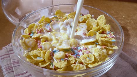 flocos de maíz amarillos crujientes en el cuenco para la mañana un delicioso desayuno con leche. cámara lenta con toma de seguimiento de rotación.