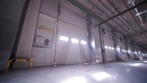 there are automatic gates at a large warehouse. the gates are used for loading cargo from large trucks.