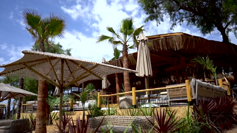 Beautiful-beach-resort-on-sunny-day-with-calm-breeze-blowing-through-palms-and-plants