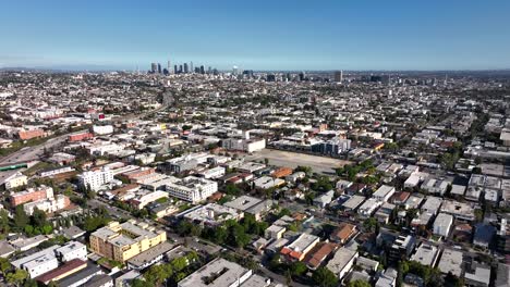 hollywood neighborhood of apartments and businesses on a hot clear blue sky afternoon, aerial forward view in city of los angeles