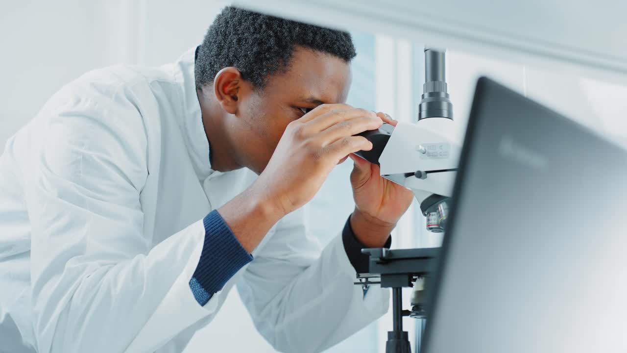 Scientist using a microscope in a laboratory setting