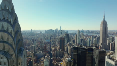 Forwards-fly-around-Chrysler-Buildings-decorative-top-section.-Cityscape-in-backlit.-Manhattan,-New-York-City,-USA