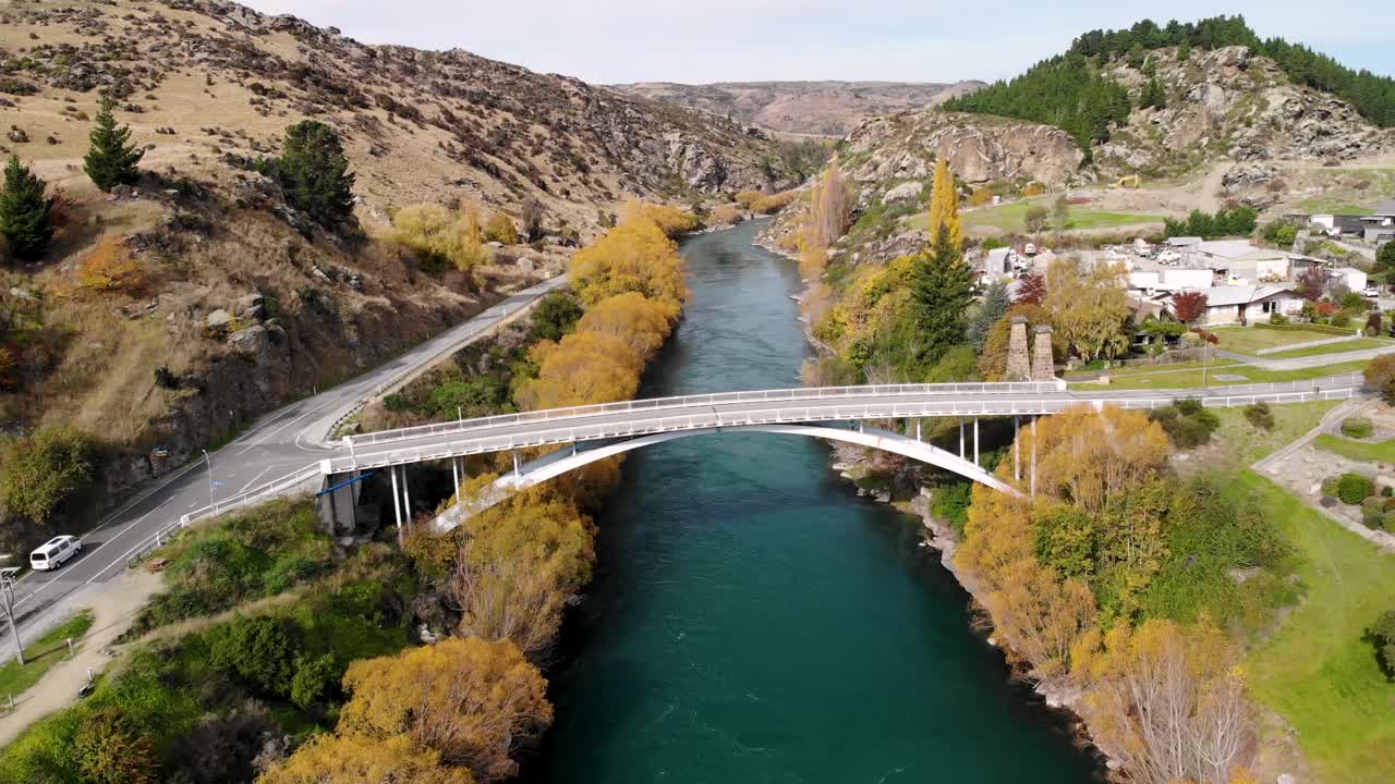 foto aérea de una furgoneta blanca cruzando el puente hacia roxburgh, nueva zelanda